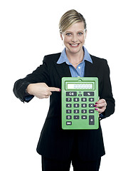 Image showing Woman pointing at big calculator