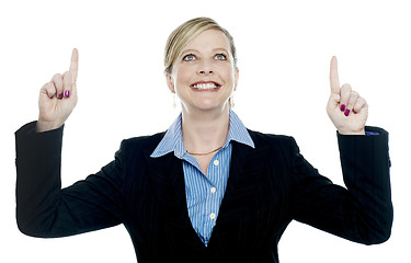 Image showing Corporate lady pointing upwards with both hands