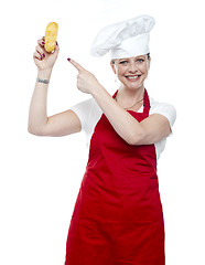 Image showing Experienced female cook pointing at bread