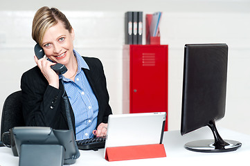 Image showing Smiling female secretary attending phone call