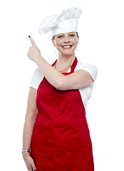 Image showing Smiling female cook pointing away