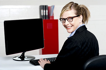 Image showing Business lady turning back and smiling at camera