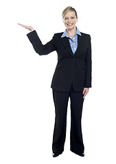 Image showing Smiling corporate lady presenting copy space