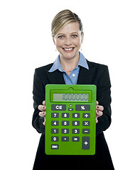 Image showing Businesswoman showing big green calculator