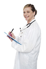 Image showing Smiling aged surgeon holding pen and clipboard