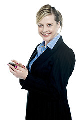 Image showing Smiling corporate lady using cellphone