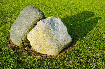 Image showing Two big stones in meadow surrounded with cut grass 