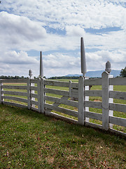 Image showing White picket fence in garden to rural meadow