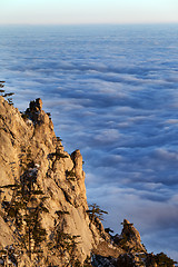 Image showing Sunlit cliffs and sea in clouds