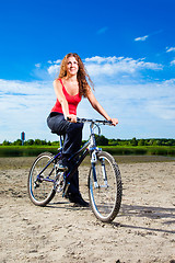Image showing beautiful woman with bicycle at the sea
