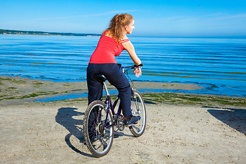 Image showing beautiful woman with bicycle at the sea