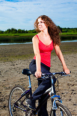 Image showing beautiful woman with bicycle at the sea