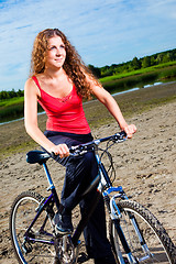 Image showing beautiful woman with bicycle at the sea