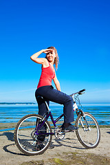 Image showing beautiful woman with bicycle at the sea