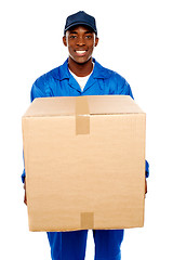 Image showing Delivery guy holding big parcel and smiling