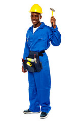 Image showing Young african repairman holding hammer
