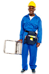 Image showing African repairman holding stepladder