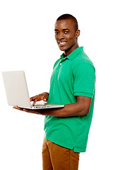 Image showing Cool teenage guy surfing internet on laptop