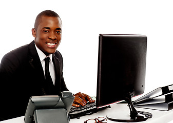 Image showing Smiling young corporate man using computer