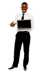 Image showing Cheerful male executive pointing at open laptop