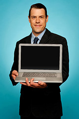 Image showing Corporate executive showing laptop to you