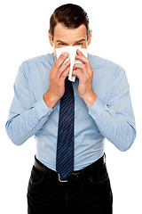 Image showing Young man having severe cold. Sneezing