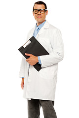 Image showing Doctor in glasses carrying clipboard