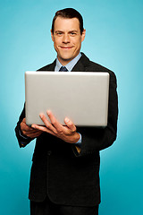 Image showing Attractive businessman holding laptop