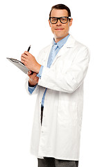 Image showing Medical expert posing with report and pen
