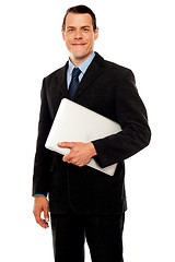 Image showing Handsome business executive holding laptop