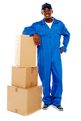 Image showing Courier boy standing beside boxes