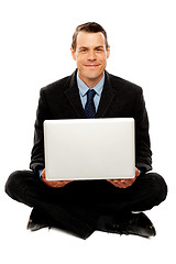 Image showing Male executive with laptop sitting on the floor