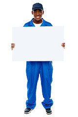 Image showing Courier guy presenting blank white billboard