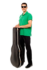 Image showing Trendy young man posing with guitar case
