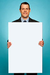 Image showing Corporate man holding big white blank billboard