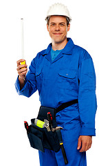 Image showing Building worker holding measuring tape