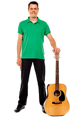 Image showing Young guitarist standing with guitar