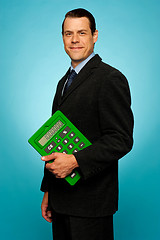 Image showing Side view portrait of a businessman with calculator