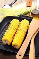 Image showing  Grill corn and spatula in frying pan.