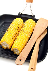 Image showing Grilled corn and wooden spoon in the pan.