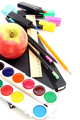 Image showing Pencils, pens and a notebook with an apple on a white background