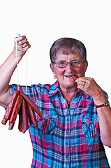 Image showing female butcher with smoked sausage