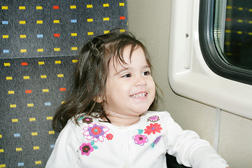 Image showing Cute little girl looking window inside a moving train