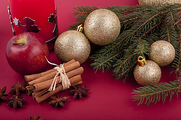 Image showing christmas decoration red apple, cinnamon, anise and tree on red background