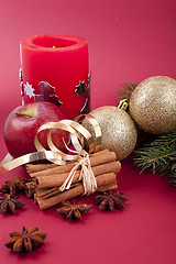 Image showing christmas decoration red apple, cinnamon, anise and tree on red background