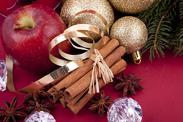 Image showing christmas decoration red apple, cinnamon, anise and tree on red background