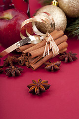 Image showing christmas decoration red apple, cinnamon, anise and tree on red background