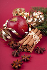 Image showing christmas decoration red apple, cinnamon, anise and tree on red background