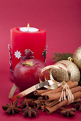 Image showing christmas decoration red apple, cinnamon, anise and tree on red background