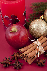 Image showing christmas decoration red apple, cinnamon, anise and tree on red background